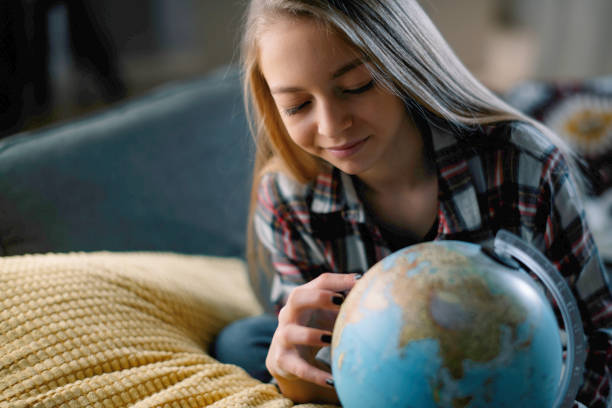 niña con globo terráqueo - curiosity searching discovery home interior fotografías e imágenes de stock