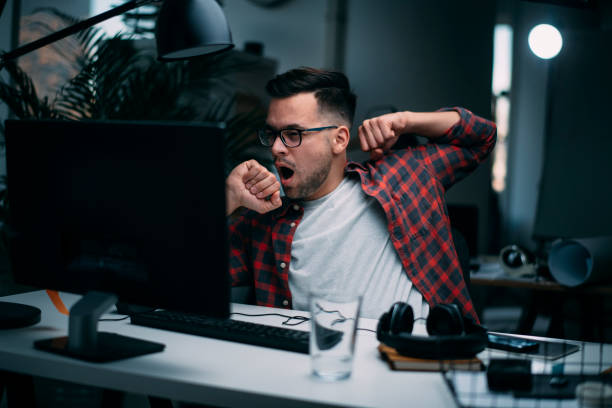 istock Tired businessman working on lap top. 1215007638