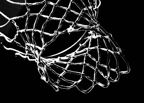 Empty Swooshing Basketball Net Close Up with Dark Background in Black and White