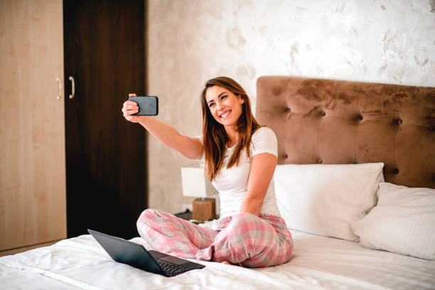 istock Smiling woman making selfie in bed 1215009167