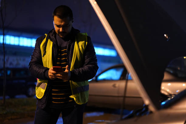 istock Man standing next to broken car and calling for help with mobile phone 1215011286
