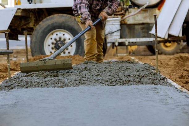 istock Construction worker pour cement for sidewalk in concrete works with mixer truck with wheelbarrow 1215011350