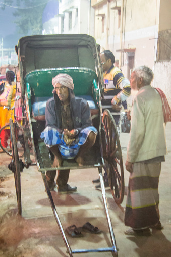 December 15, 2019 - Kolkata, India: Indian rickshaw puller sitting on his rickshaw and waiting for passengers in Kolkata. India