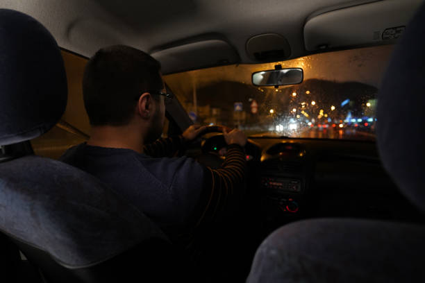 istock Man driving at night through the city 1215011800