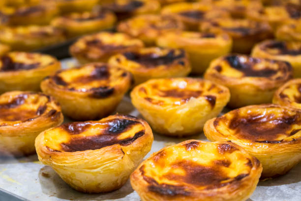Typical Portuguese custard pies "Pastel de Nata" or "Pastel de Belem". Traditional portuguese pastry. On a wooden table. pasteis de belem stock pictures, royalty-free photos & images