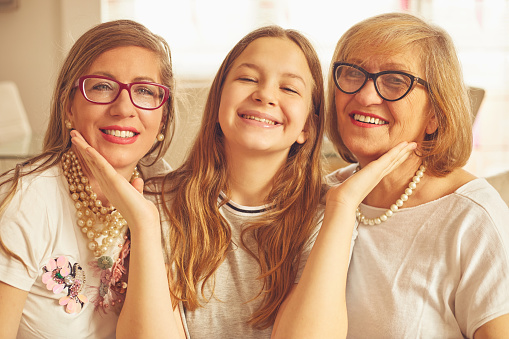Portrait of three generation of women. Smiling, talking and enjoying at home.
