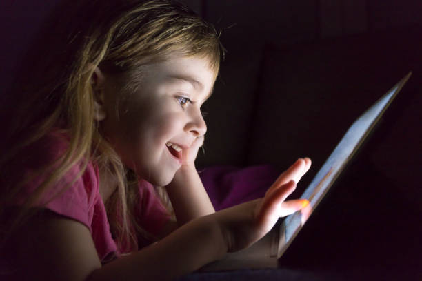 istock Young girl lying in bed and using digital tablet at night 1215018604