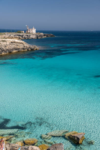 Wonderful seewater in Favignana, Sicily The transparent seewater of Cala Azzurra with the lighthouse on the promontory in Favignana, Aegadian Islands, Sicily favignana photos stock pictures, royalty-free photos & images