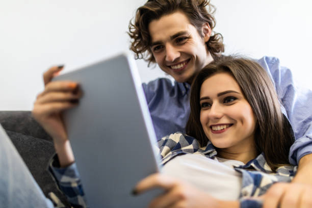istock Young in love couple using a tablet computer in their living room 1215022127