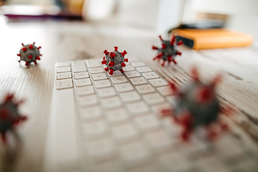 Close up model of corona virus on desk and keyboard in office