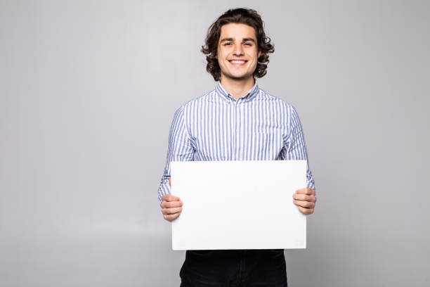 istock Happy young man showing and displaying placard ready for your text or product isolated on white background 1215027320