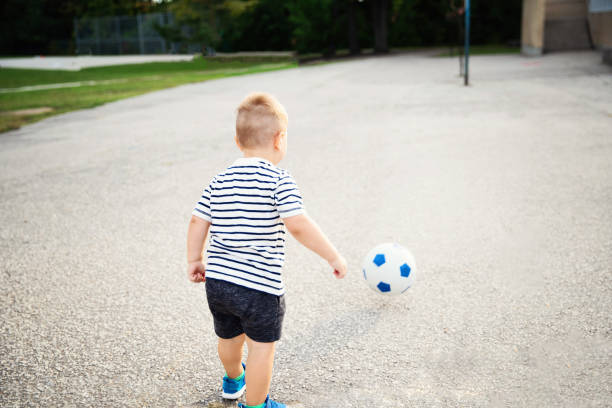 istock Young Boy Chasing a Soccer Ball 1215028031