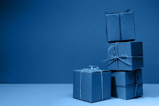 istock Craft cardboard gift boxes on the solid classic blue  background. Holiday and gift concept 1215028055
