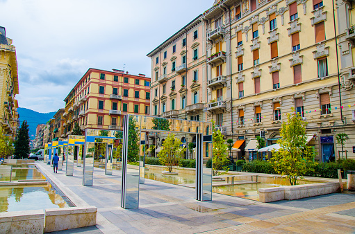 La Spezia, Italy, September 13, 2018: alley with modern mirror arches with reflection by Daniel Buren on Piazza Giuseppe Verdi square among buildings in historical city centre, Liguria