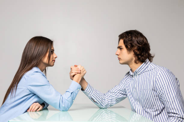 istock Beautiful couple doing arm wrestling challenge isolated on white background 1215029153