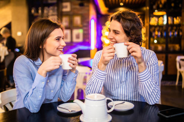 istock Cute couple having coffee or tea together in cafe 1215030296