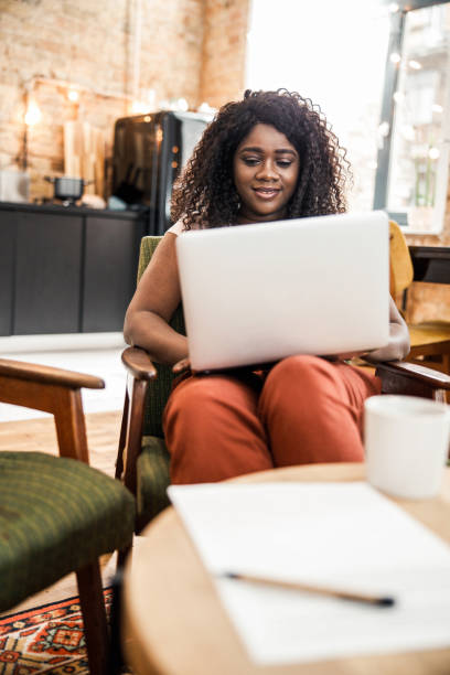 istock Beautiful Afro American lady using notebook at home 1215033411