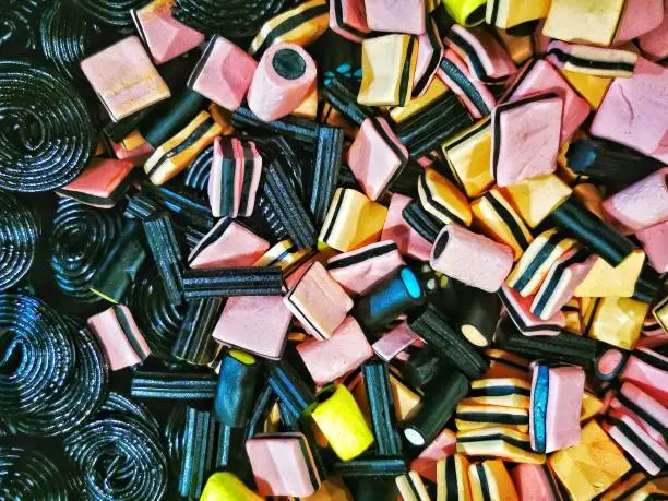 Unique view of a bin of black and mutli colored licorice candies.