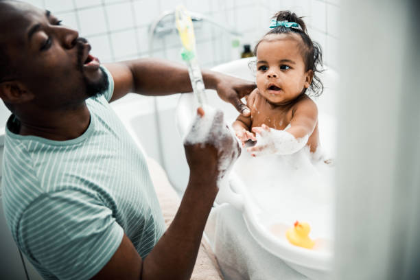 istock Cute newborn child taking bath and playing with daddy 1215034045