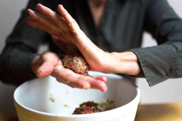 istock Woman Rolling Meatballs Close-Up 1215034259
