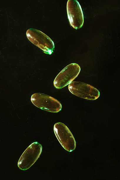 istock Transparent gel capsules on dark black background 1215040409