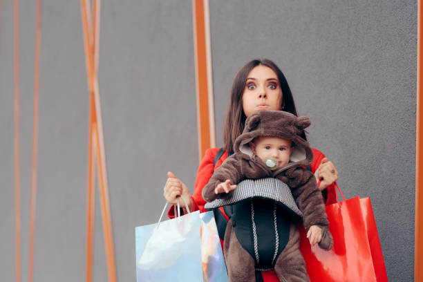 プレゼントの買い物中に赤ちゃんを運ぶ疲れたお母さん - christmas emotional stress shopping holiday ストックフォトと画像