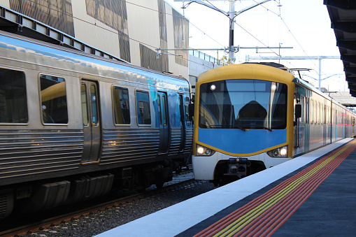 Brisbane, Australia - Nov 20, 2017:  A Queensland Rail peak hour service to Ipswich arrives at Brisbane's Roma Street Station Platform 8. Electric commuter train, curved railway station platform.