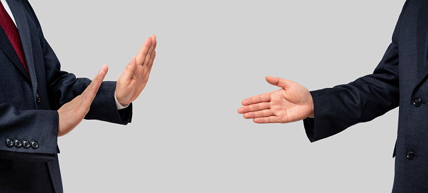 Los hombres de negocios se enfrentan y recomiendan un apretón de manos y los hombres de negocios que se niegan. Distancia social. photo