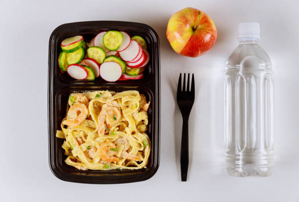 istock Ready meal to eat on food container with water and apple. 1215055546