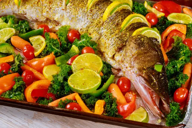 Healty dish with pike fish and vegetable in oven tray.
