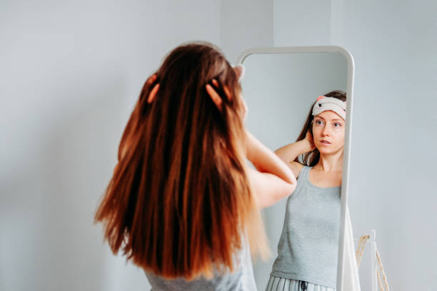 istock Woman looking in the mirror in sleeping mask getting ready for the day 1215064037