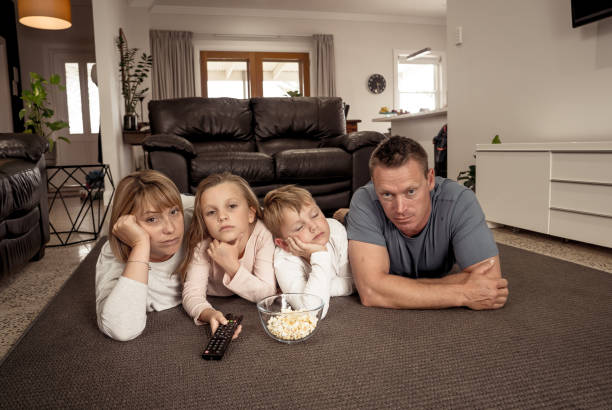 istock Coronavirus lockdow. Bored family watching tv helpless in isolation at home during quarantine COVID 19 Outbreak. Mandatory lockdowns and self isolation recommendations forces families stay home. 1215066590
