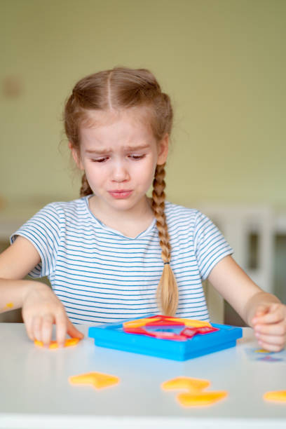 istock close up. upset girl solve mathematical puzzle. 1215068193