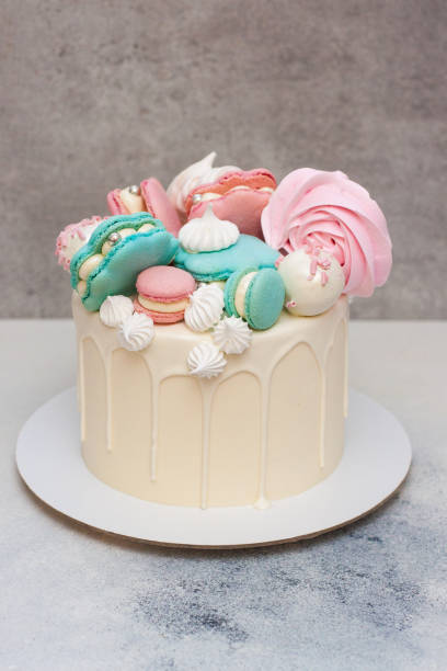 istock Elegant white cake with macaroon sea shells, chocolate and meringue decoration, grey background 1215068479