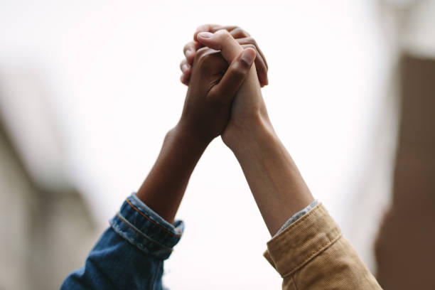 demonstrators protesting together holding hands - anti governments imagens e fotografias de stock