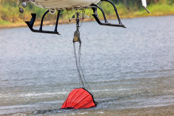 istock Firefighting helicopter refills water bucket in a pond 1215072019