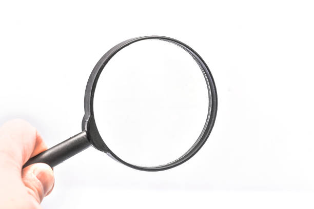 istock Close-up holding a magnifying glass on a white background. 1215073382