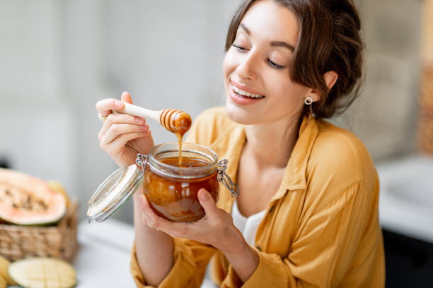 istock Woman eating honey at home 1215073523