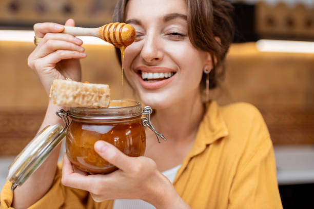 istock Woman eating honey at home 1215073621