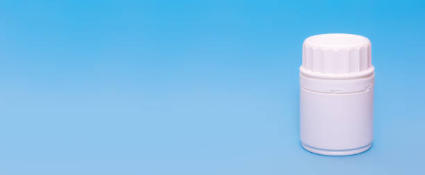 istock White medical bottle vial on a blue background.Copy space for text.Banner 1215075182