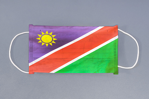 Isolated medical mask with flag of Namibia on gray background. Closeup protective masks textile filter. Health care and medical concept. Coronavirus, virus in Namibia.