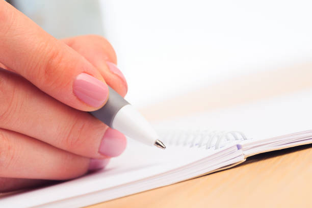 istock female hands write in a notebook . Office place . Close up view 1215080167