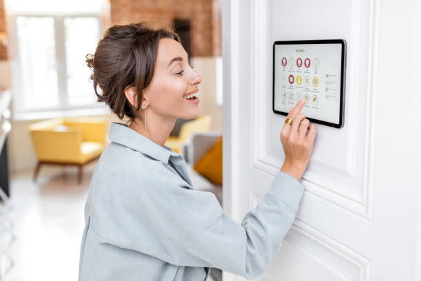istock Woman controlling home with a digital touch screen 1215080500