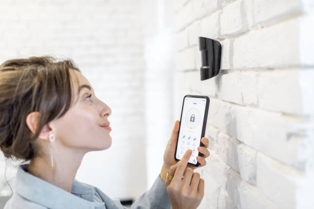 istock Woman controlling alarm system with a smart phone 1215080693