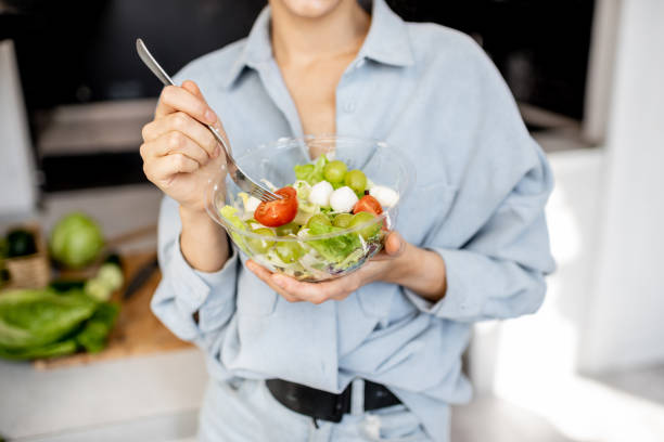 istock Woman eating healthy salad on the kitchen 1215081406