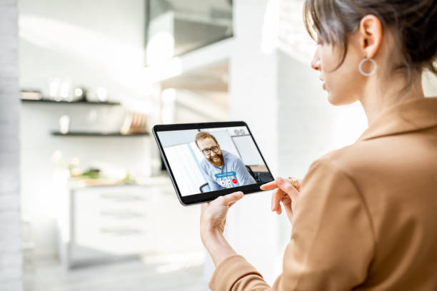 istock Woman talking with coworker using digital tablet 1215082364
