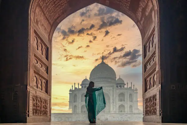 Photo of Woman in traditonal culture dress saree or sari in the Taj Mahal, Taj Mahal is most beautiful white marble mausoleum in the Indian city, Agra, Uttar Pradesh, India.