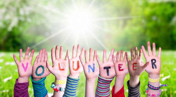 istock Children Hands Building Word Volunteer, Grass Meadow 1215084382