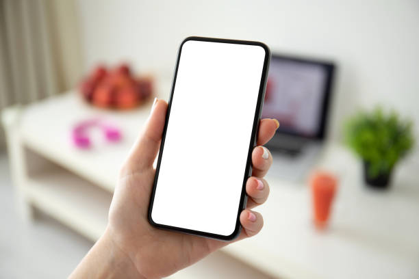 istock female hand holding phone with isolated screen on background room 1215084407