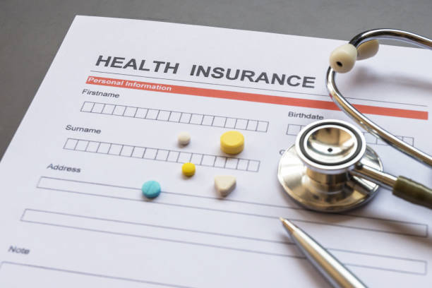 istock Health insurance form with model and policy document 1215085559